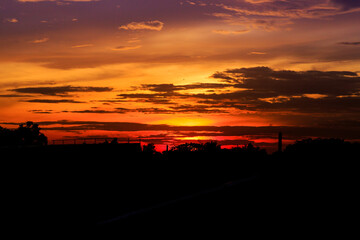 Obraz premium Orange twilight sky with clouds and shadows of objects in the evening.