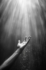 Obraz premium Underwater Serenity - Hand Reaching Towards Sunlight in Monochrome