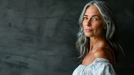 Fototapeta premium A woman with silver hair gazes confidently toward the camera