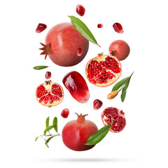 Fresh pomegranates, seeds and leaves in air on white background