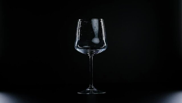water is poured into a glass on a black background