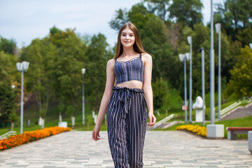 Young beautiful blonde woman posing on summer street