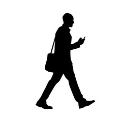 Silhouette of a man walking while using a smartphone