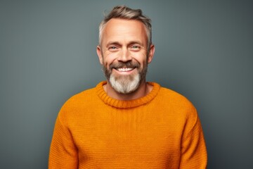 Obraz premium Portrait of a cheerful man in his 40s dressed in a warm wool sweater isolated in solid color backdrop