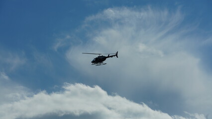 One helicopter flying over in the blue sky in autumn