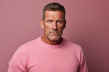 Obraz premium Portrait of a merry man in his 50s sporting a long-sleeved thermal undershirt over solid color backdrop