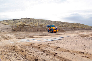 Bulldozer leveling a beach section for a seasonal beach pavillion in Noordwijk