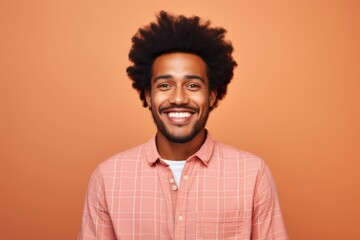 Fototapeta premium Portrait of a cheerful afro-american man in his 20s dressed in a relaxed flannel shirt in solid color backdrop