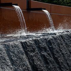 Water pours from a gutter and falls on a stone