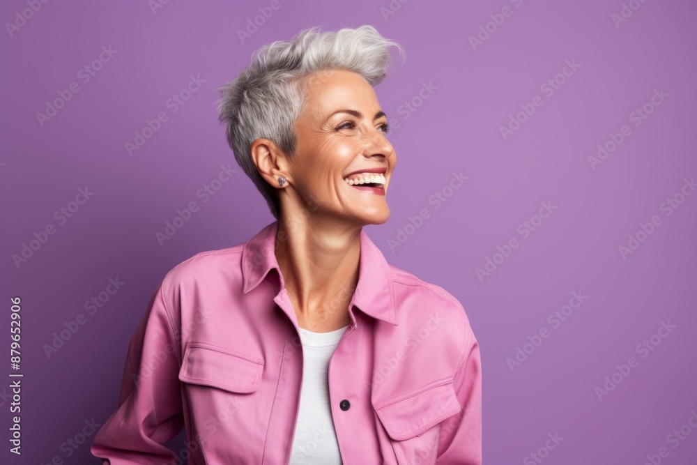 Wall mural Portrait of a happy woman in her 50s dressed in a water-resistant gilet in solid pastel color wall