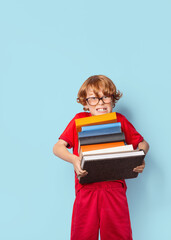 boy with many books. Overwhelmed by the learning concept.