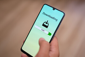 'Download' concept on the smartphone screen. File upload and download. Close-up. 
