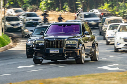 Dark blue Rolls Royce Cullinan Novitec on city street, Luxury SUV panning shot, High Resolution