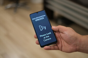 'Face Recognition' message on mobile device screen. Biometric data and device security concept. 