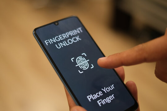 Biometric Identification. Men Unlocking Smartphone Scanning Fingerprint With Personal Verification App At Workplace Indoor, Top View. Phone Authorization Concept