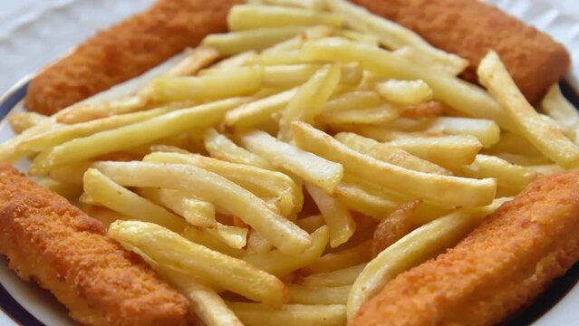 Fish and chips or french fries on the plate. Close-up. Selective focus. 