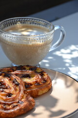 Glass cup of coffee  and  puff pastry outdoor on table in shade