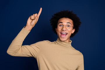 Photo portrait of handsome young man point up eureka dressed stylish beige garment isolated on dark blue color background