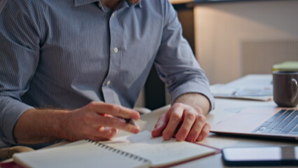 Businessman hands making notes at notebook indoors closeup. Tired man pondering