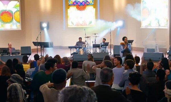 Christian worship God together in Church hall in front of music stage.