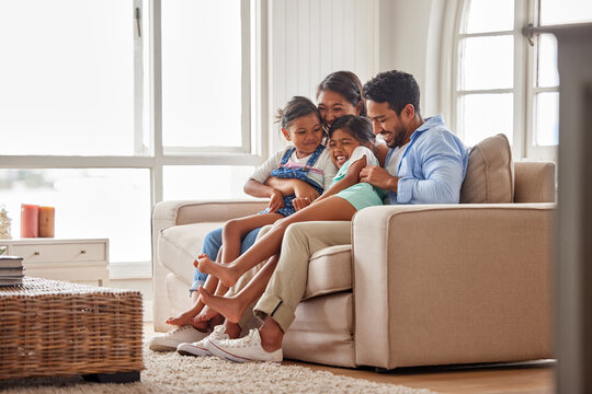 Family, couch and hug in home living room for support, relax and unity with parents in lounge. Love, together and house for calm with mom and dad, bonding and smile and weekend holiday in Florida