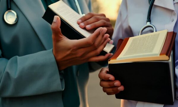 Hands holding stethoscope and the Bible and pray for healing, concept for treatment, science and religion, close up hands praying, with copy space , space for text