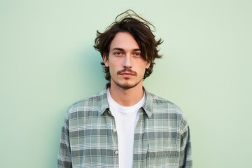 Fototapeta premium Portrait of a tender man in his 20s wearing a comfy flannel shirt on solid pastel color wall
