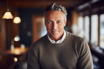 Obraz premium Portrait of a glad man in his 40s dressed in a warm wool sweater over scandinavian-style interior background