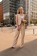 Fototapeta premium woman walking in sunny city street with phone