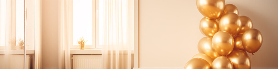 A large cluster of shiny gold balloons in front of a cream colored wall and sheer curtain.