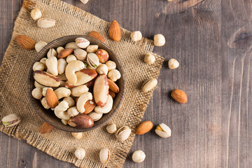 Healthy mix nuts on wooden background. Almonds, hazelnuts, cashews, peanuts, pistachios, Brazil nuts