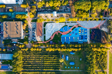 Fototapeta premium Top view of park sports fields in park between autumn trees