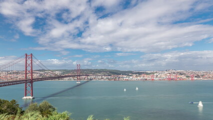 Fototapeta premium Panorama showing Lisbon cityscape and Tagus river timelapse with 25 of April bridge