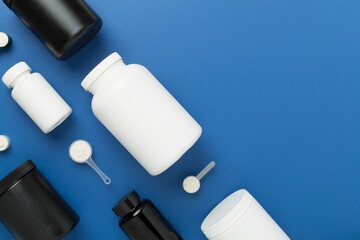 Jars with protein powder on color background, top view. Sports nutrition concept