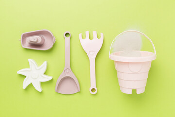 Cute toys for playing with sand on color background, top view