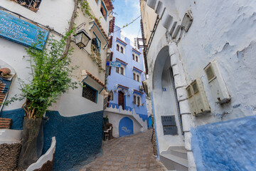 Chefchaouen, Morocco - March 25, 2024: A quaint alley with blue and white buildings. The town is known for its blue-washed walls and charming, labyrinthine streets.