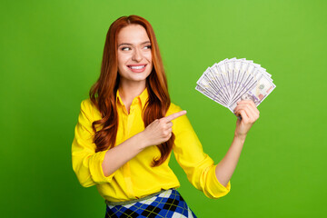 Photo of adorable cute nice woman wear yellow trendy clothes hold cash wealth isolated on green color background