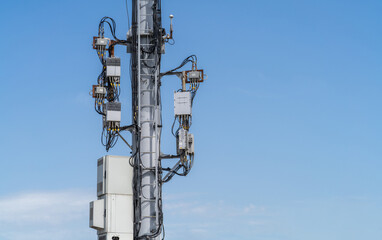 Telecommunications hub equipment, remote radio unit RRU, uninterruptible power source, cable entry for optical cables. Cell tower with new telecommunications and 4G and 5G wireless equipment.