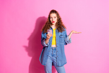 Photo of doubtful pretty lady dressed denim jacket typing modern gadget arm empty space isolated pink color background