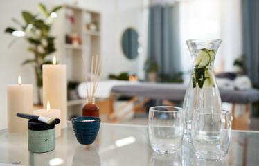 Relax, interior and spa with supplies for treatment, water container and candle for feeling zen or peace. Table, equipment and empty room in health resort for massage, calm and aromatherapy diffuser