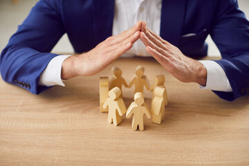 Business employer executive manager protecting rights of employees. Man holding hands over group of...
