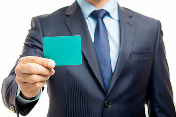 A man in a suit holding a green card. The card is likely a business card or a card for a special occasion. The man is dressed professionally and he is confident and well-prepared