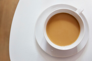 Birds eye view of a cup of coffee in a round white china cup on saucer