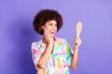 Photo of pretty young woman look hold hairbrush wear shirt isolated on violet color background