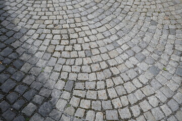 Obraz premium Brick road surface with stones in curved pattern