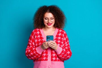 Photo of charming positive woman wear red cardigan spectacles chatting instagram twitter telegram facebook isolated blue color background