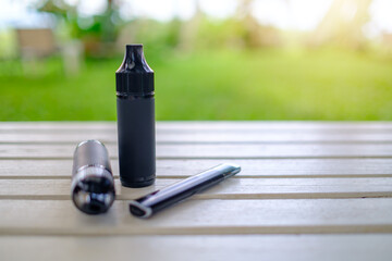 Vaping electronic cigarettes or vape devices on a table. Modern way of Smoking E-cigarette as an...