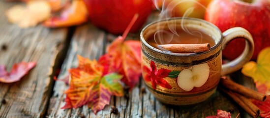 Warm Apple Cider with Cinnamon Stick and Autumn Leaves