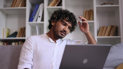 Sad young indian man talk with psychotherapist at online distance remote counselling session indoors Depressed male discussing problem with psychological support by laptop computer at home