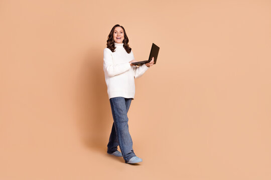 Photo of lovely adorble woman wear stylish clothes hold netbook isolated on beige color background